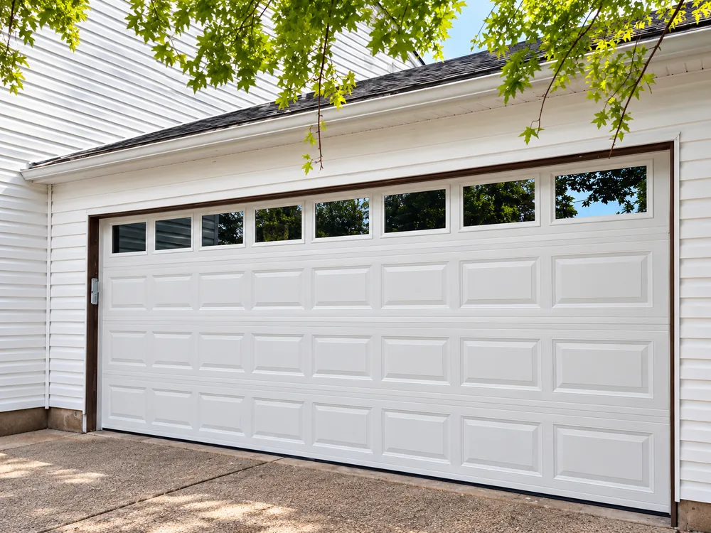 White residential garage door with decorative upper window panels