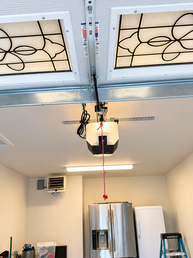Ceiling-mounted automatic garage door opener inside a residential garage